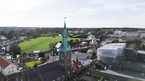 Flight-passing-closely-by-ornate-church-spire-St-Peter-Port-Guernsey-on-bright-sunny-day