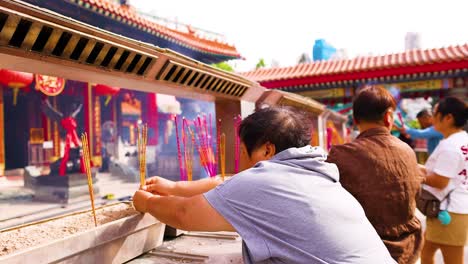 people offering incense at a hong kong temple