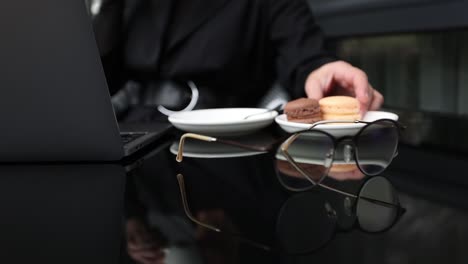 woman working at laptop with macaroons