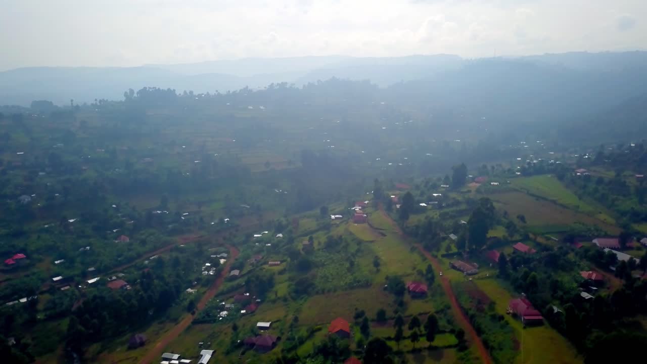 Aerial view of Kapchorwa town in Eastern Uganda with dense haze, cloudy sky, and lush green vegetation indicating the wet season during a humid morning