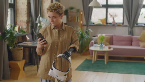 girl with prosthetic arm holding vr headset and using smartphone at home