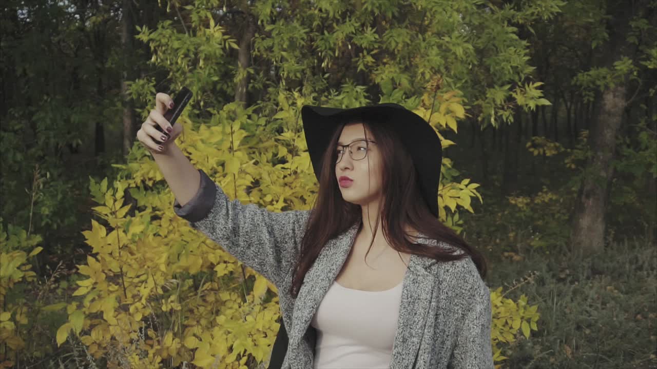Woman Taking a Selfie in Autumn Park