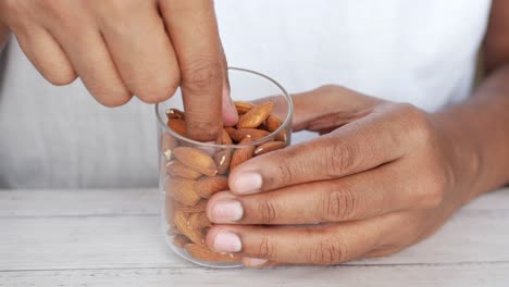 persona que sostiene un vaso de almendras