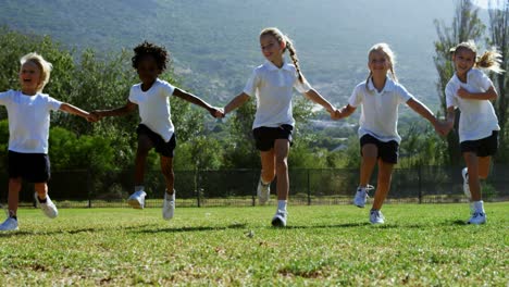 School-kids-holding-hands-and-running-in-park