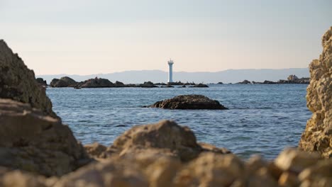 Wunderschön-Gerahmte-Aussicht-Auf-Den-Leuchtturm-Zwischen-Felsen-Mit-Meer