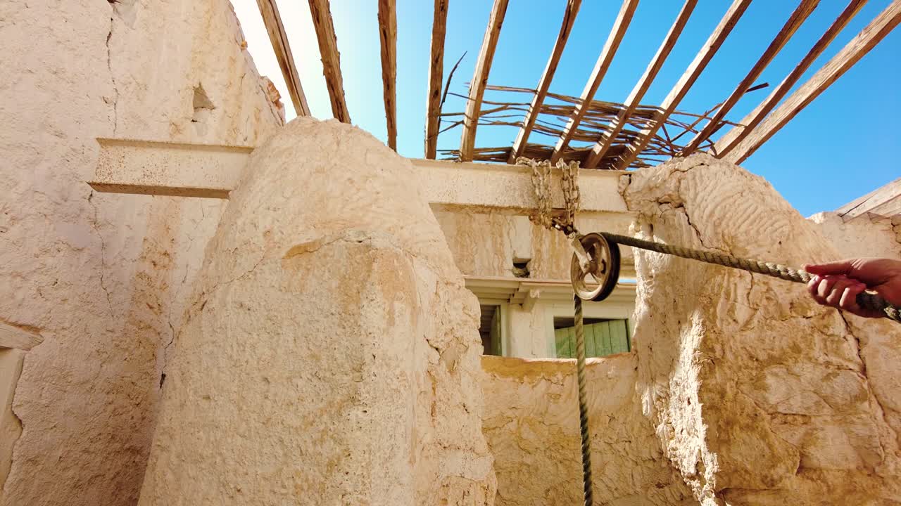 a man pulls on the rope to remove the seal from the well