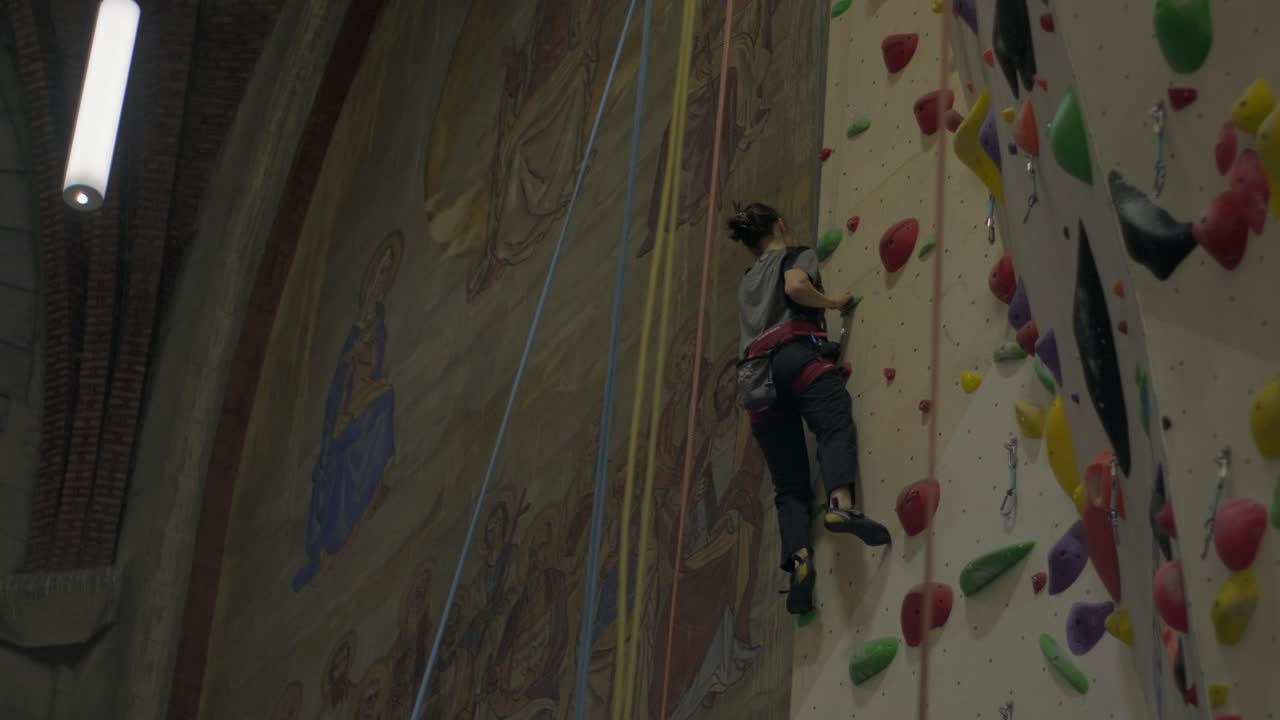 escalador asciende a la pared interior en el entorno histórico de la iglesia