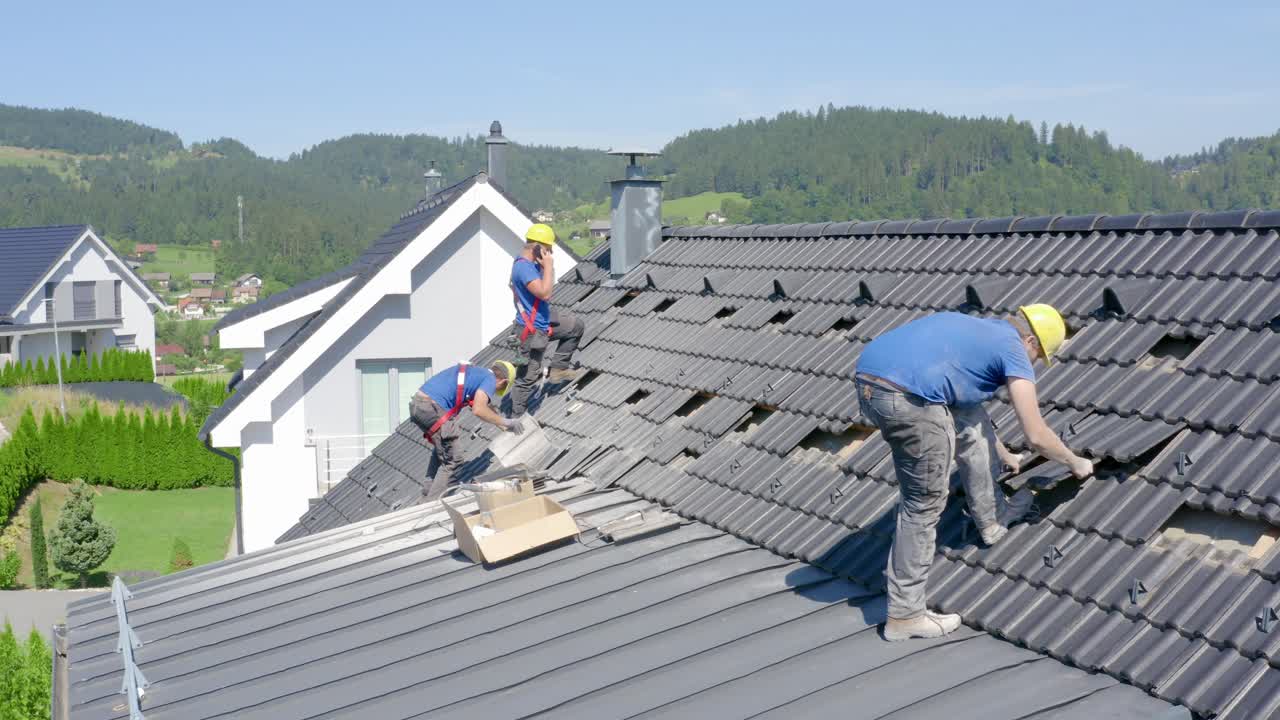 Drone pov of workers installing solar panels on roof of building, Slovenia