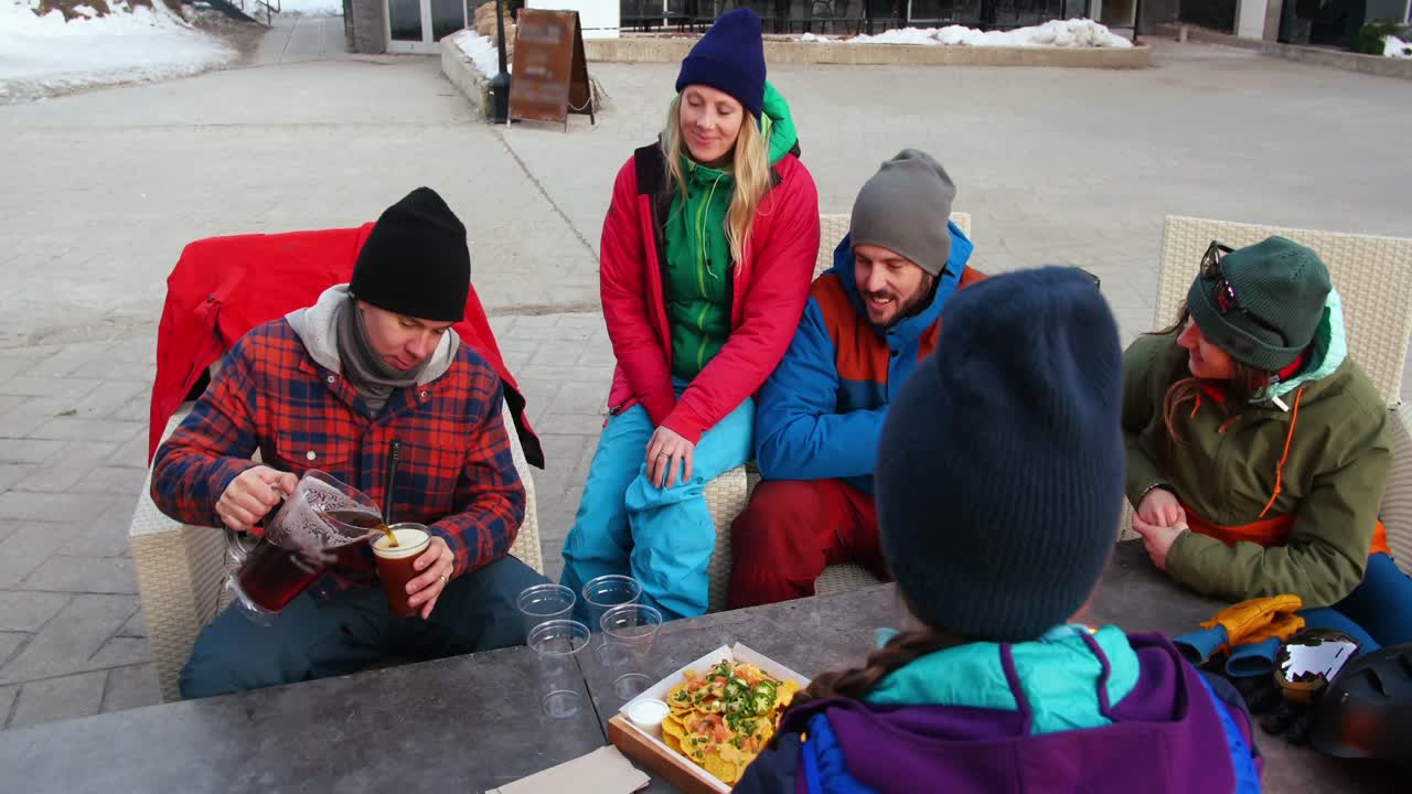 amigos comiendo bocadillos cerca del fuego de campamento