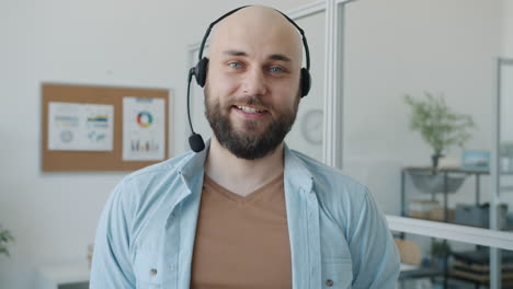 smiling businessman wearing headset in office