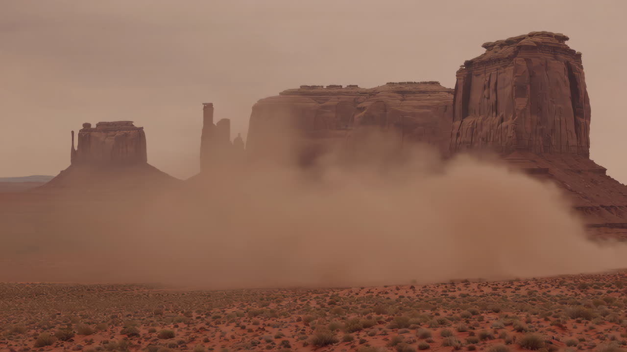 Dust Storm Sweeping Across a Desert Landscape with Large Rock Formations