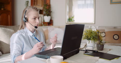 representante de ventas en auriculares hablando con el cliente y haciendo videoconferencia en la computadora portátil 10