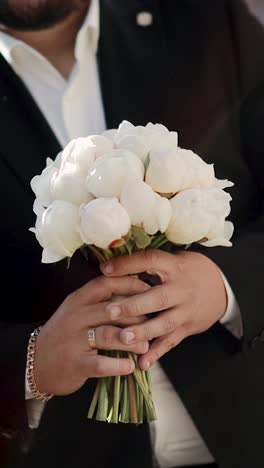 hombre caucásico guapo con barba sosteniendo flores