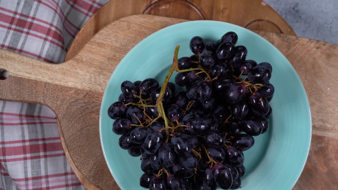 rotación circular un ramo de uvas negras en un plato, vista de arriba