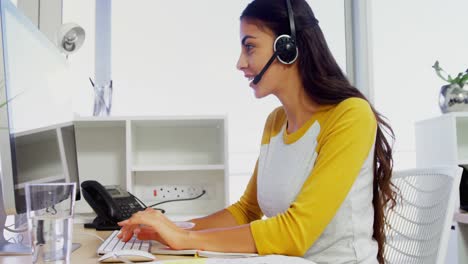 ejecutivo de negocios con auriculares usando computadoras en el escritorio en la oficina 4k