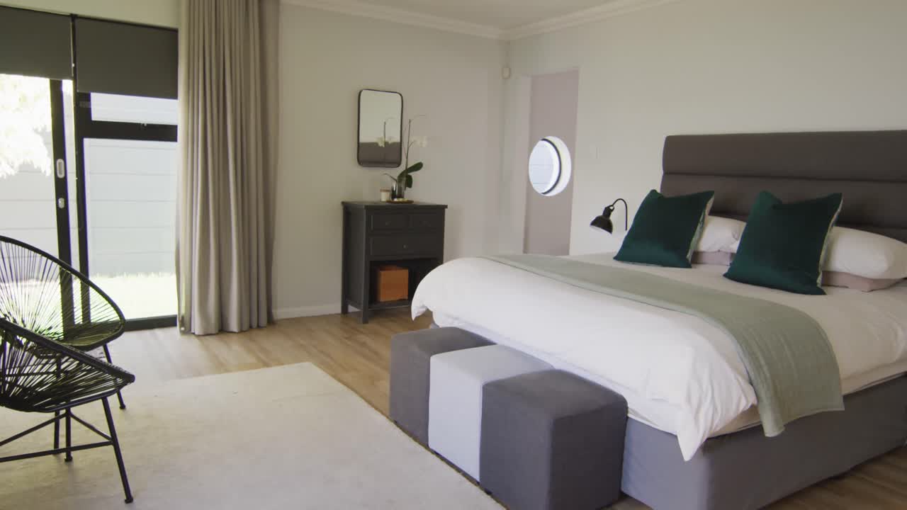 Vista generale di una camera da letto di lusso con ampio letto e comodini.