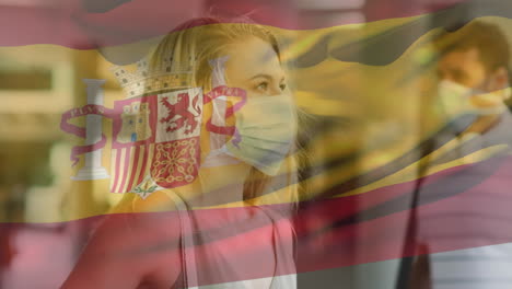 animation of flag of spain waving over woman wearing face mask during covid 19 pandemic