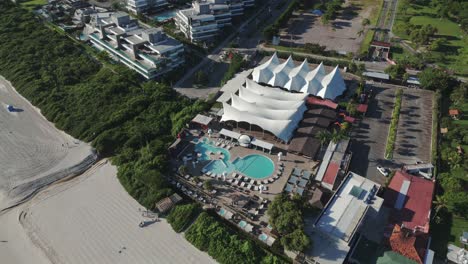 a drone circling around p12, showcasing its marvelous facilities for parties and events in jurerê internacional beach, florianópolis