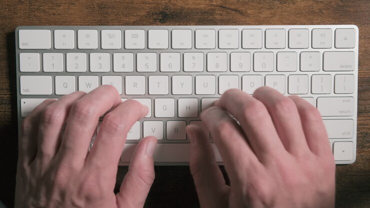 Male Hands Typing Text On A white modern Keyboard,close up shot