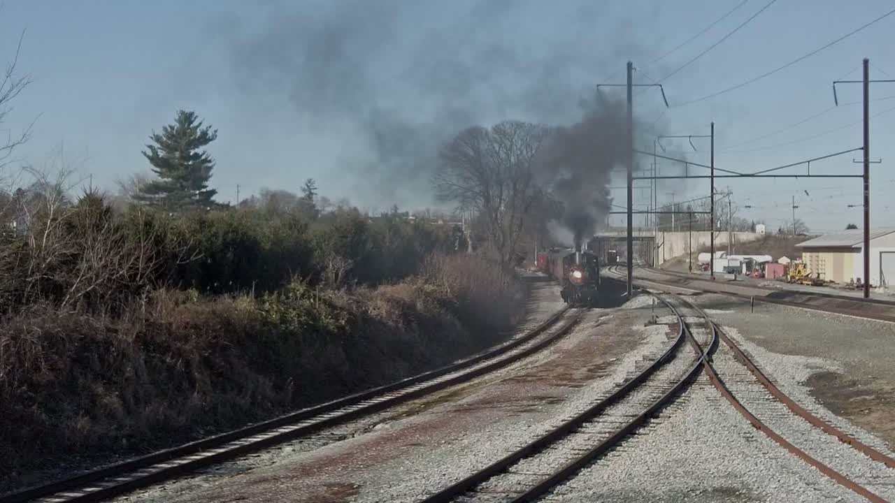 An Aerial View of a Steam Locomotive and Passenger Train Starting Up With Smoke and Steam