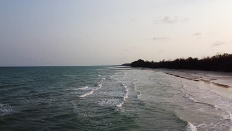 Aerial-time-lapse-side-view-of-Long-Ocean-waves-reach-the-shore-in-Southern-Thailand