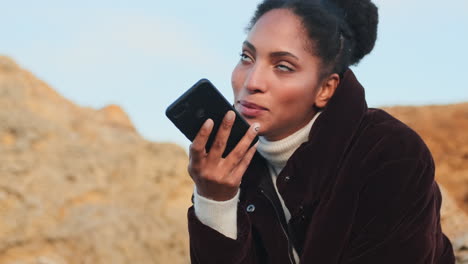 african american girl recording voice message on phone.