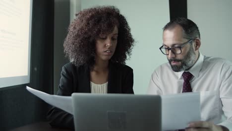 two serious businesspeople sitting together and discussing