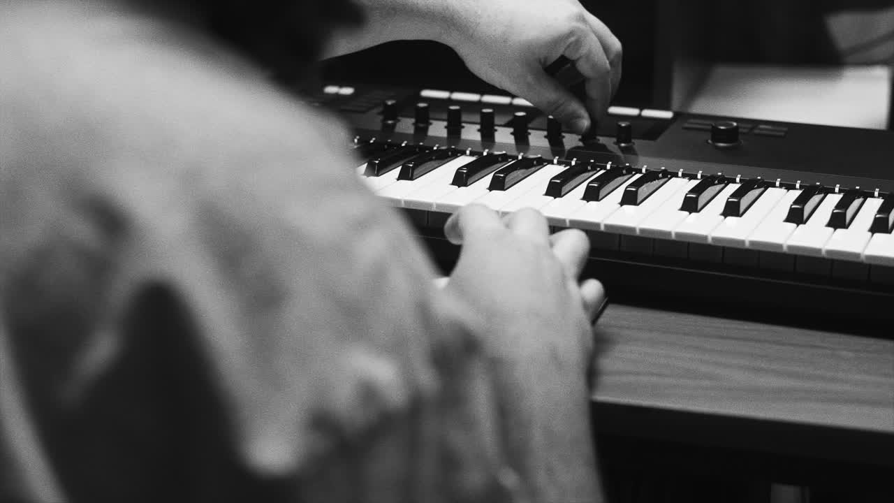 Person playing a midi keyboard in a music studio