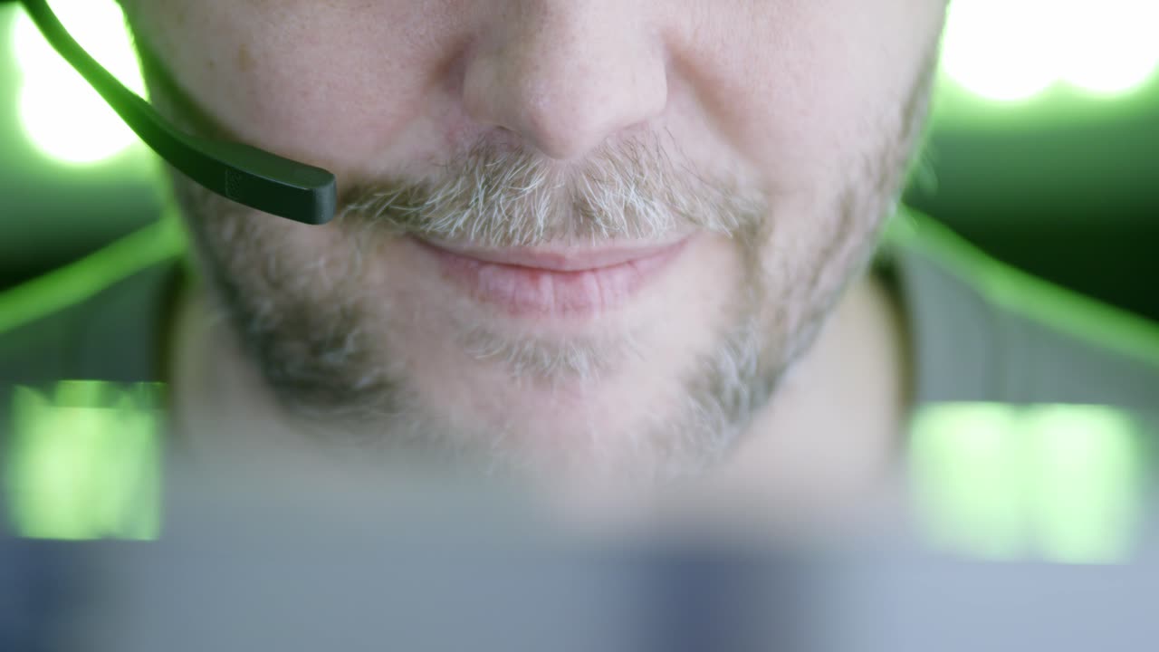 Dybdeskarphet nærbilde av skjeggete mannlig kundeservicerepresentant på telefon