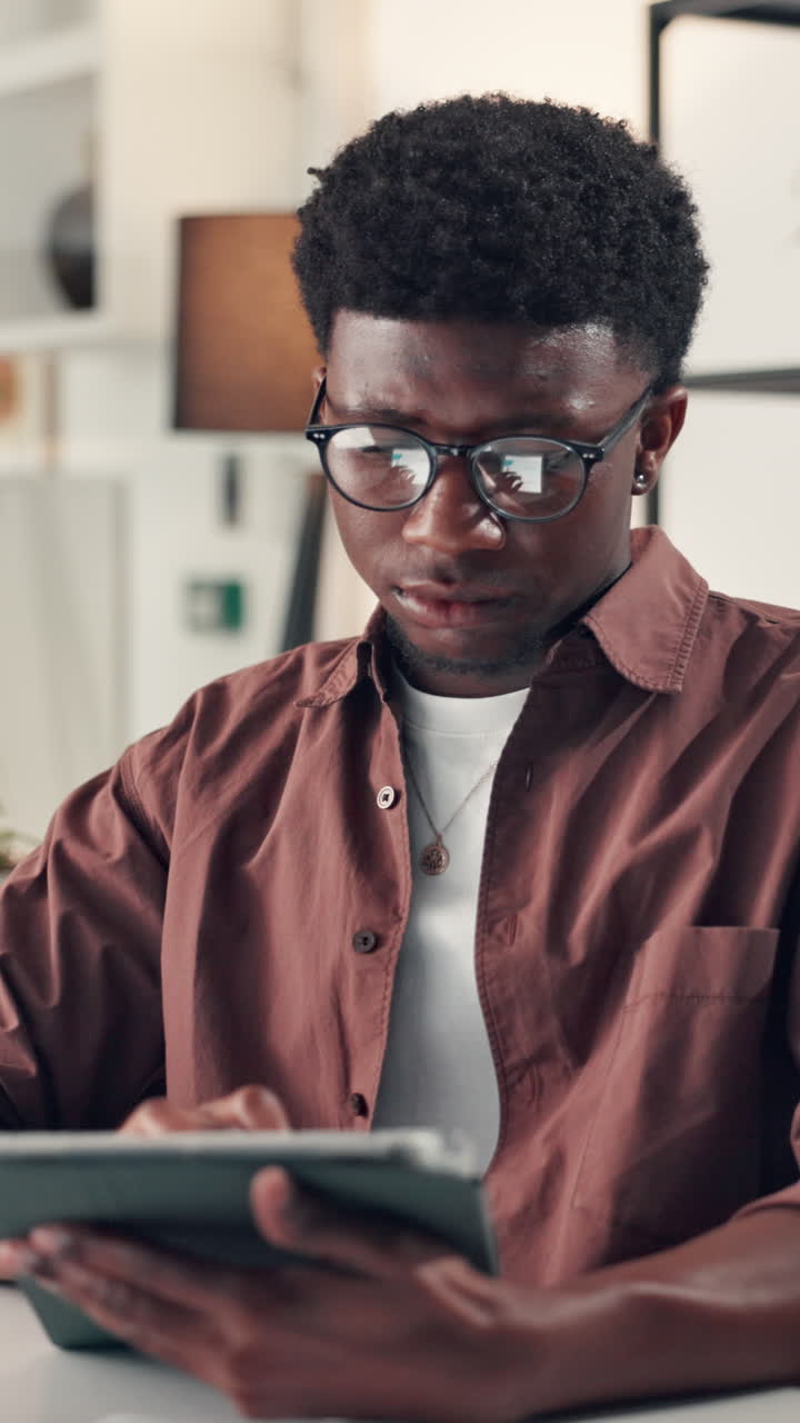 Young Black Man Smiling While Using a Digital Tablet