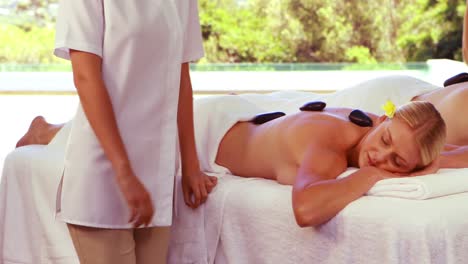 relaxed couple having hot stone massage