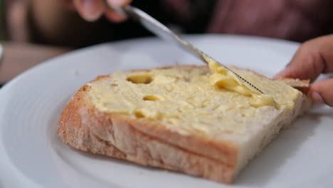 mantequilla esparcida sobre una rebanada de pan