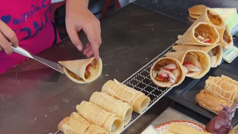 making conical crepes at a street food stall