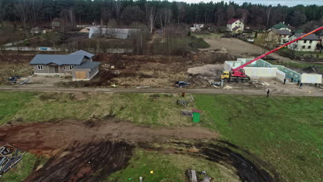 construction workers on site building, lifting prefabricated house by crane, aerial drone