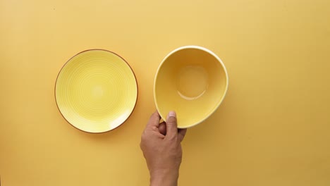 plato y cuenco amarillos vacíos en una superficie amarilla