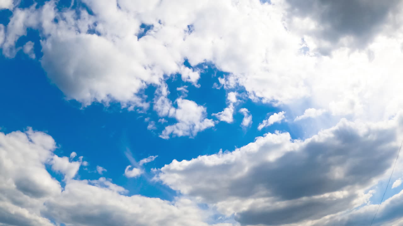 Beautiful white clouds transforming quickly in the atmosphere. Soft cloudscape in the light of the sun. View from below. Timelapse.