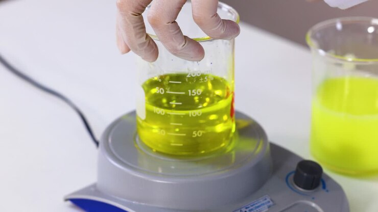 Mani che eseguono un esperimento di reazione chimica colorata