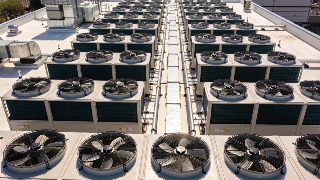 Activating from sunlight, condenser array spinning fans on rooftop with service walkway for cooling