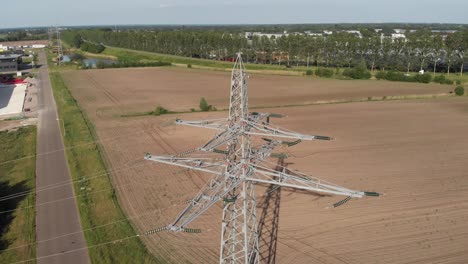 transmission tower and power line energy supply in rural countryside setting, aerial view