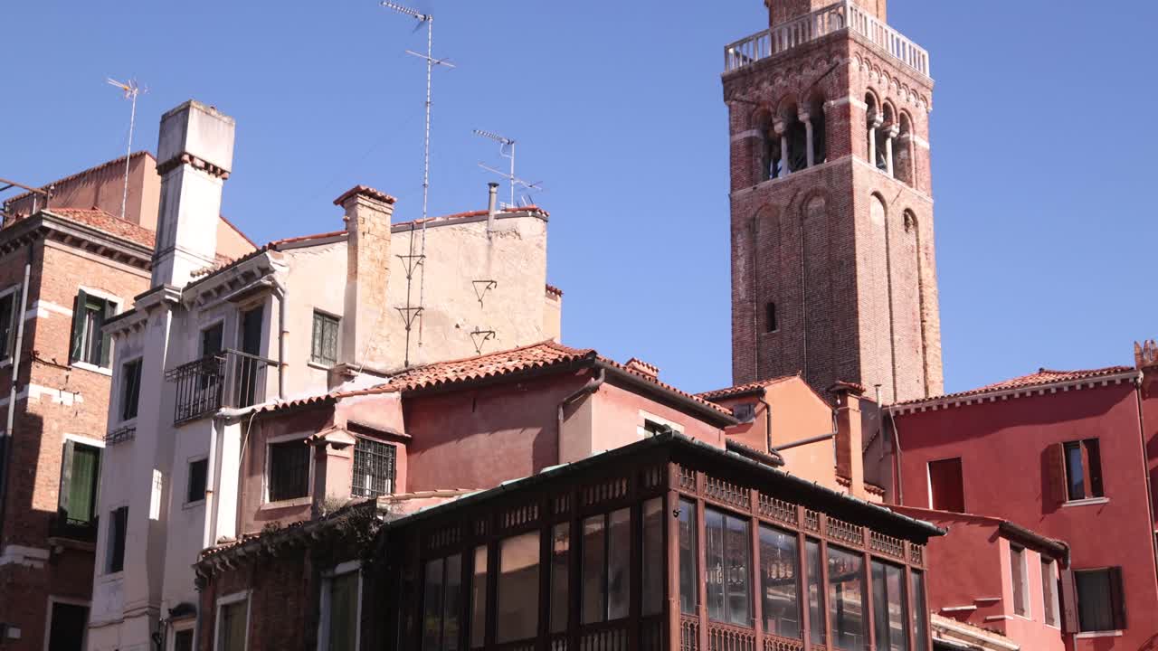 Historic Venetian bell tower standing tall against a clear blue sky.