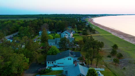 aerial of a sunny maine beach cottage by the sea. spacious deck, scenic ocean views, and sandy yard make this prime real estate perfect for vacation, family getaways, or year-round living.