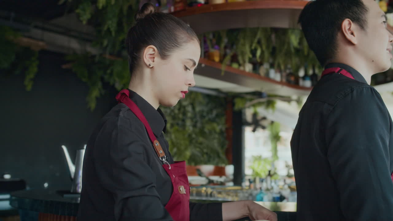 Waitress Tying Up Apron of Her Male Colleague in Cafe