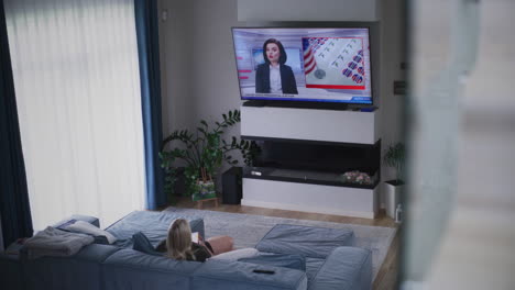 woman watching political news on tv