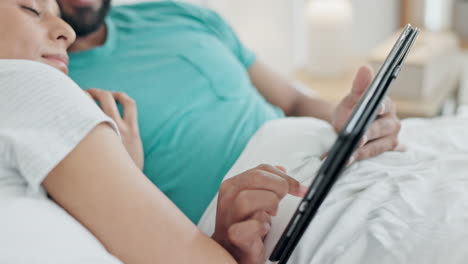 manos, tableta y primer plano de una pareja en la cama