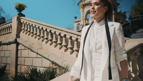 Stylish-young-woman-walking-down-stairs-outdoors.