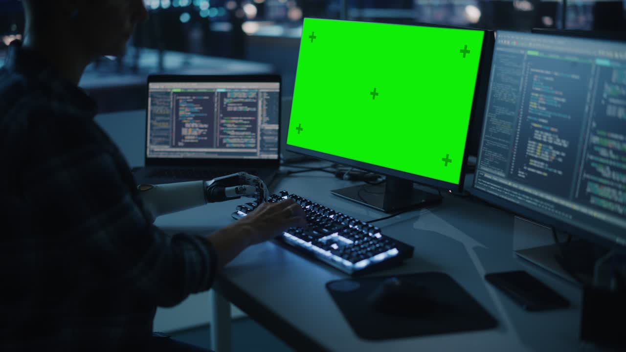 oficina nocturna: persona con discapacidad que utiliza un brazo protésico para trabajar en una computadora de pantalla verde. uso rápido y natural de la mano myoeléctrica biónica para escribir código para software por la noche. arco medio