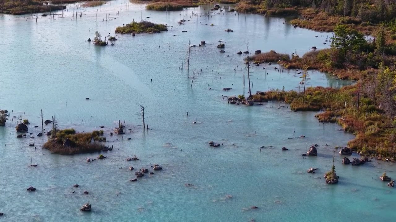 An aerial view of a wilderness lake with blue water near Hessel in Michigan's Lake Huron region, as seen from a drone.