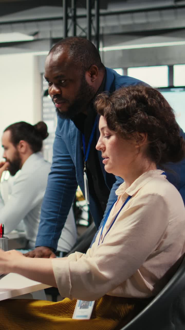 Vertical Video Diverse office coworkers reviewing monthly data graphs to create reports