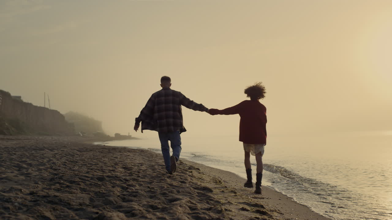 una pareja amorosa caminando por la playa. una chica y un chico felices disfrutando de la puesta de sol de verano en el mar