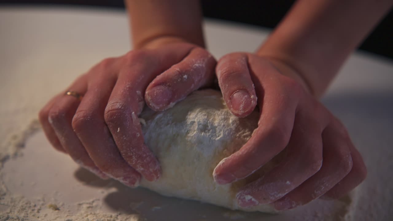 Close-Up of Hands Kneading Dough on a Floured Surface